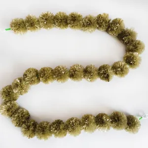 Detailed view of olive green plastic marigold flower garland arranged in an S-shape