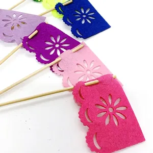 Close-up of colorful felt Mexican Day of the Dead cake topper flags with floral cutouts