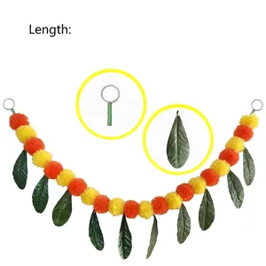 Detailed close-up showing texture of marigold pom poms and mango leaf decorative garland