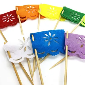 Close-up of colorful Day of the Dead felt cake toppers with intricate floral cutouts