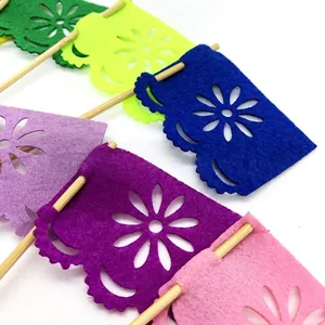 Close-up detail of colorful felt floral cutout cake toppers for Day of the Dead dessert decor.