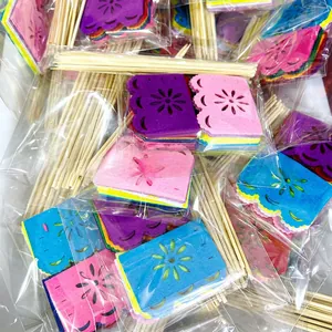Detailed view of colorful Day of the Dead cake toppers in individual plastic packaging