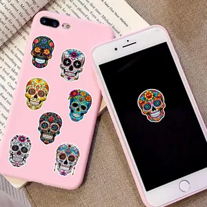 Colorful Mexican Day of the Dead sugar skull stickers displayed on a pink phone case background