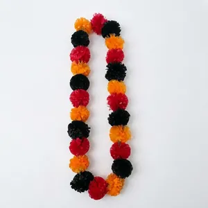 Detail shot of colorful red, orange, and black marigold garland for festive decor