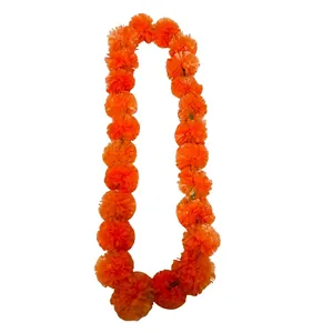 Close-up of vibrant orange fabric marigold garland for Day of the Dead.