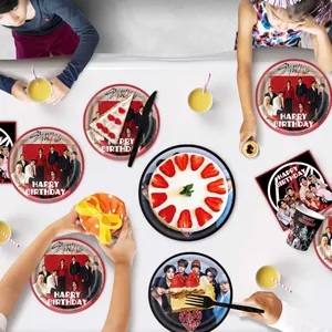 Detail showing Stray Kids themed birthday party supplies with printed plates and napkins