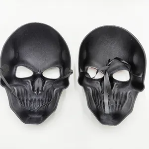 Detailed view of two black skull masks for Halloween, showing elastic band and ribbon ties