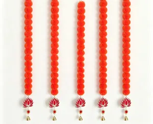 Close-up detail of orange marigold garlands with lotus pendants and golden bells