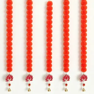 Handmade orange marigold pom-pom garlands with red lotus pendants and gold bells