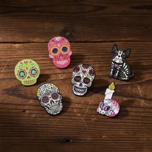 Detailed view of various colorful Day of the Dead sugar skull enamel pins on a rustic wood surface