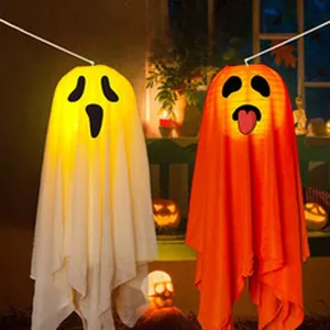 Glowing Halloween ghost hanging lanterns in white and orange with spooky face designs