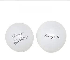 Close-up of white birthday balloons with 'Happy Birthday to you' cursive script