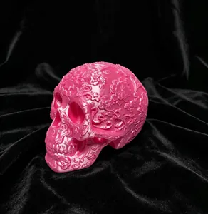 Macro view of a 3D printed pink skull ornament featuring intricate floral engravings