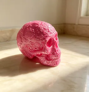Detailed view of a pink 3D printed floral skull with intricate Day of the Dead carvings.
