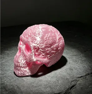 Detailed close-up of a 3D printed pink carved skull featuring intricate floral motifs.