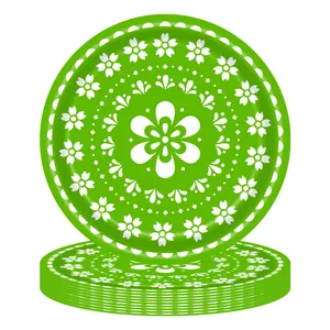 Detail view of vibrant green disposable paper plates with white floral Day of the Dead pattern.