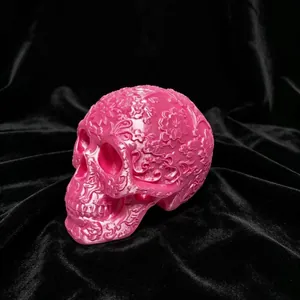 Pink 3D printed skull ornament with intricate floral carvings for Day of the Dead decor