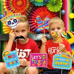 Detailed view of colorful Mexican Fiesta photo booth props being used in a party setting