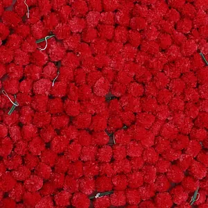 Detailed close-up showing the texture of vibrant red plastic marigold flowers for festive decor