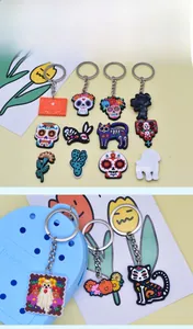 Detailed close-up view of assorted Day of the Dead themed PVC charms and bag keychains