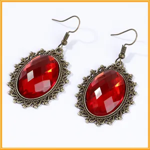 Detailed view of vintage ornate earrings with large faceted red crystals