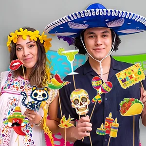 Selection of colorful Mexican Day of the Dead photo booth props held by party guests