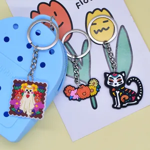 Vibrant Day of the Dead PVC keychains featuring cartoon ghost cat and floral designs for bags