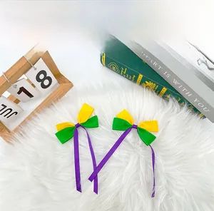 Mardi Gras themed ribbon bow hair clips set with purple yellow green colors in a studio shot.