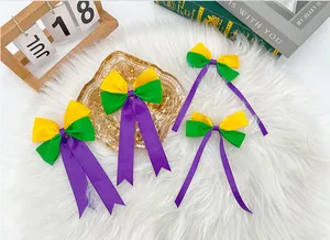 Close-up detail of purple, green, and yellow Mardi Gras bow hair clips with long ribbons