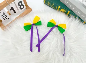 Detailed view of purple green and yellow Mardi Gras ribbon bow clips on white rug