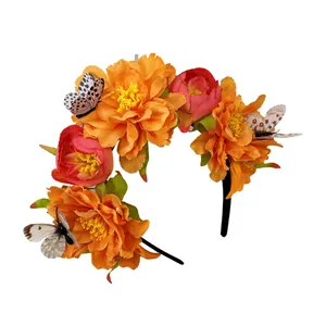 Vue détaillée du serre-tête floral avec grandes fleurs orange et papillons décoratifs