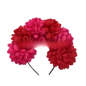Detailed view of large red and pink artificial fabric flowers on a festive headband