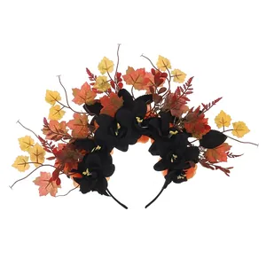 Detail view of Halloween headband with black artificial flowers and autumn maple leaves.