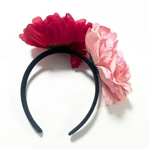 Detailed view of oversized 12cm red and pink camellia flowers on a party bridal headband