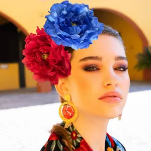 Close-up of a model wearing a large red and blue artificial camellia flower headband