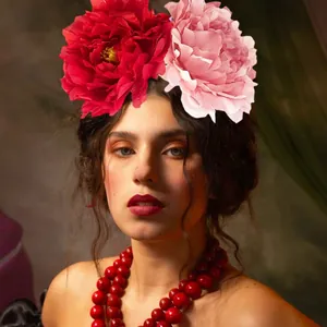 Close-up of oversized red and pink artificial peony flower headband for carnival party