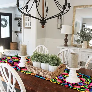 Vibrant Mexican floral table runner for Dia De Los Muertos party decor in home setting.
