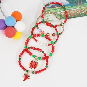 Detail view of festive Cinco de Mayo bracelets with red green beads and pepper charms