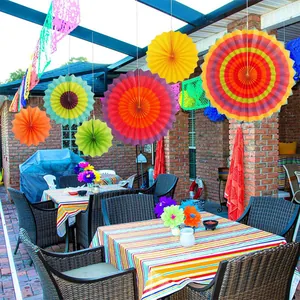 Vibrant colorful Mexican fiesta hanging paper fans decorating an outdoor patio party area