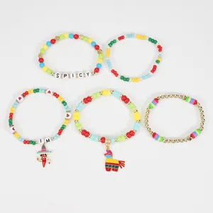 Overhead view showing variety of beaded bracelets with chili pepper and pinata charms