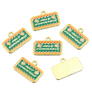 Detail of rectangular enamel charms with Holy Guacamole text and textured back view.