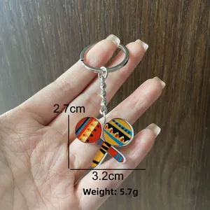 Detail of Mexico Carnival maracas keychain showing 2.7cm by 3.2cm size and weight