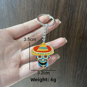 Detail view of a colorful Mexican festival acrylic skull keychain with size measurements.