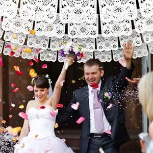 Detailed view of white laser-cut papel picado banners used in a wedding celebration