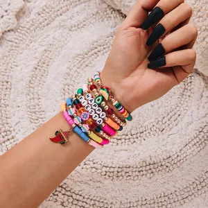 Close-up detail of colorful Cinco de Mayo beaded bracelets with chili pepper and taco charms.