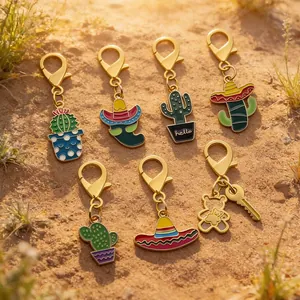 Mexican festival enamel keychains featuring cactus, chili pepper and sombrero on sand background