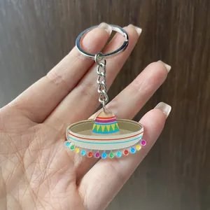 Close-up detail of a colorful Mexican festival sombrero keychain held in a hand