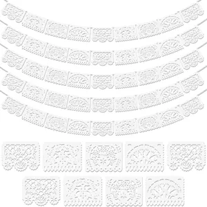Laser-cut white Mexican papel picado banners with intricate floral patterns for party decor