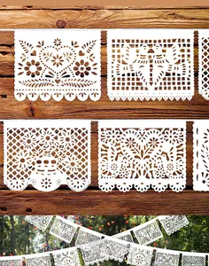 Detailed view of white Papel Picado banners with intricate floral and bird cutouts.