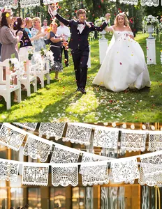 Detailed view of white Mexican Papel Picado banners with intricate cutout patterns